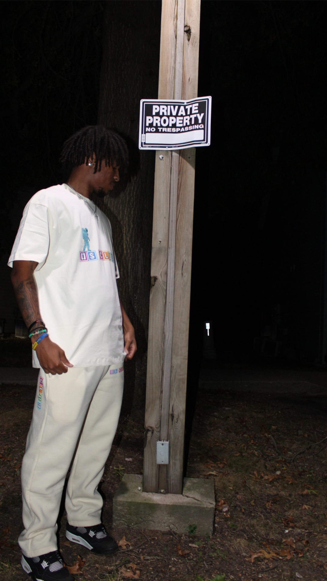 Person standing next to a 'Private Property' sign at night